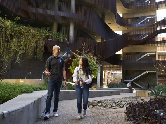 Two people walking at the ENR2 Building at the University of Arizona.