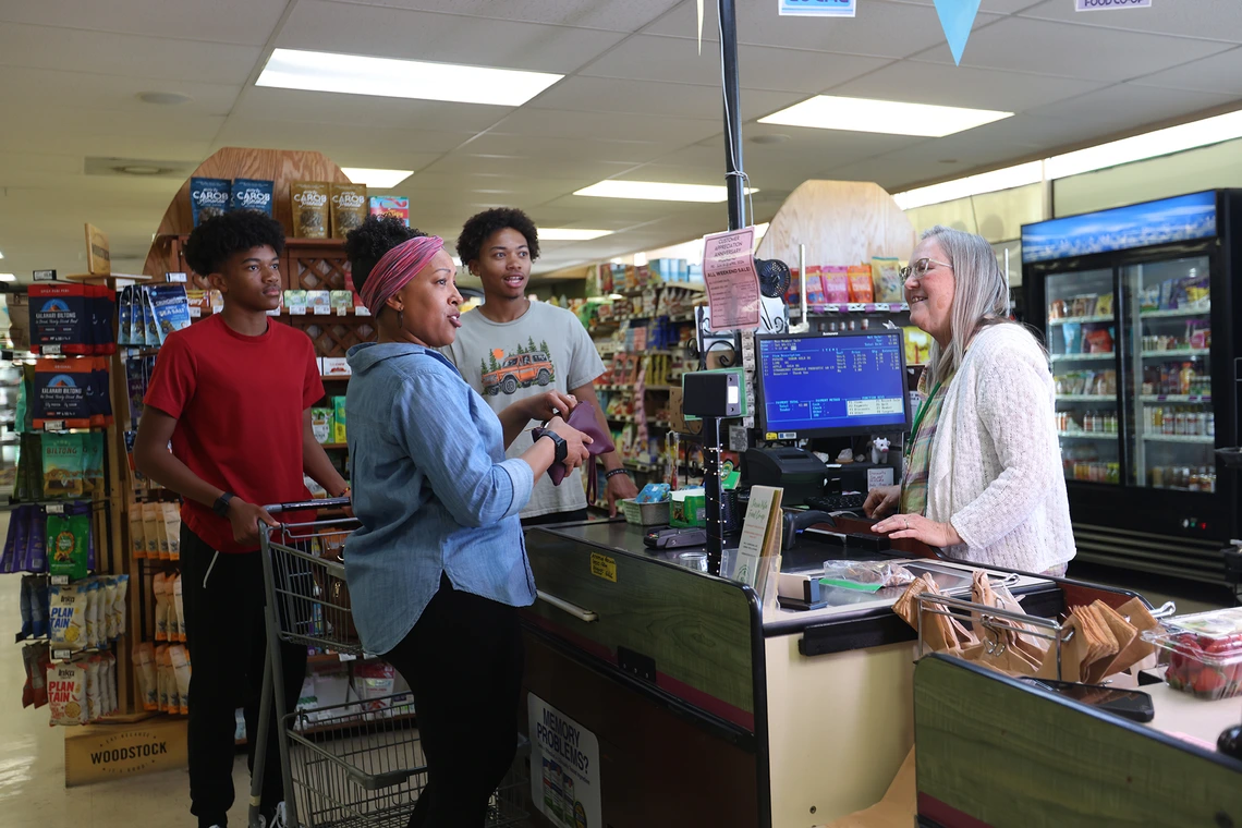 A family purchases groceries in a food coop in Cochise County